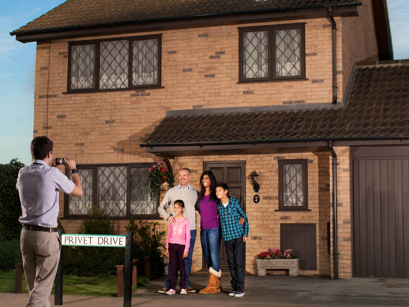 Семья позирует перед домом № 4 по Привет-стрит в The Making of Harry Potter (Warner Bros. Studio Tour)